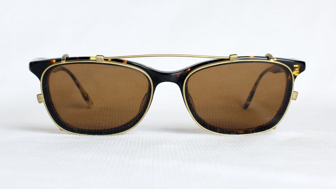 Custom clip-on sunglasses with matte gold long bar attached to prescription glasses