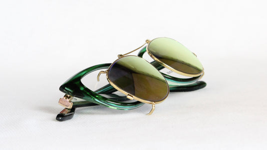 Mirror-coated custom clip-on sunglasses with curved short bar, laid flat
